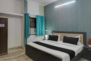 a bedroom with a large bed with blue walls at OYO Flagship Dripp Stay Inn in Lucknow