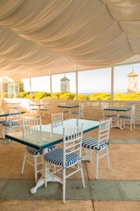 um grupo de mesas e cadeiras sob uma tenda em Hippocampus resort em Concón