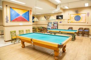 a billiard room with two pool tables and chairs at Hippocampus resort in Concón