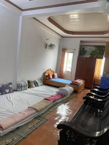 ein Zimmer mit 2 Betten und einem Stuhl darin in der Unterkunft Home Hưng Trang in Diện Biên Phủ