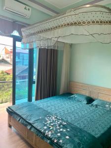 een slaapkamer met een groot bed met een baldakijn bij Home Hưng Trang in Diện Biên Phủ