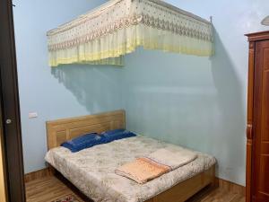 een kleine slaapkamer met een hemelbed bij Home Hưng Trang in Diện Biên Phủ