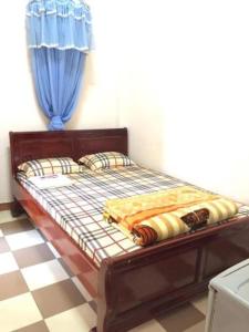 Bett in einem Zimmer mit einem blauen Vorhang in der Unterkunft Home Hưng Trang in Diện Biên Phủ