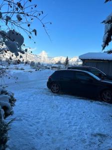 a black car parked in a snow covered driveway at Sunway Lounge in Maishofen