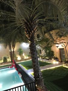 un palmier installé à côté d'une piscine dans l'établissement Glory Resort, à Al-Hassa