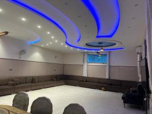 Habitación grande con luces azules en el techo. en Glory Resort, en Al-Hasa