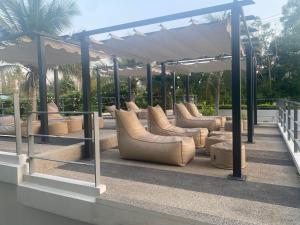 a group of couches sitting under a pavilion at The Sea Condominium in Sam Roi Yot