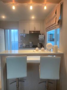 a kitchen with two white chairs and a counter at The Sea Condominium in Sam Roi Yot