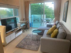 uma sala de estar com um sofá e uma televisão em The Sea Condominium em Sam Roi Yot