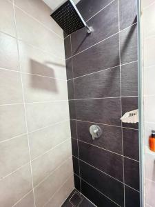 a shower with a black and white tiled wall at D'Pristine 1512A walk to Legoland Netflix bySTAY in Nusajaya