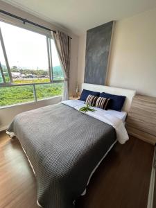 una camera da letto con un grande letto con una grande finestra di CREEK 1 BEDROOM a Kathu