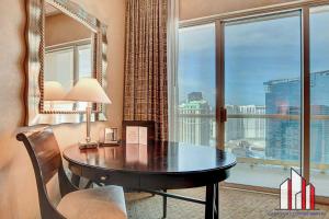 a room with a table and a large window at MGM Signature-32-607 F1 Track & Strip View Balcony in Las Vegas