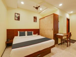 a bedroom with a large bed and a desk at Super Collection O SRP LUXURY ROOMS in Hyderabad