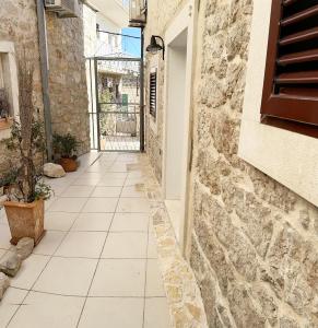 an alley with a stone wall and a tile floor at Secret House Andrea in Primošten