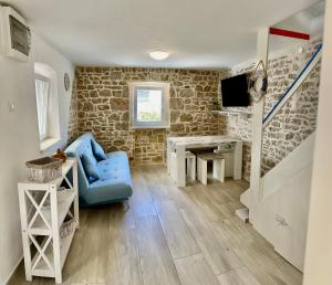 a living room with a blue couch and a desk at Secret House Andrea in Primošten