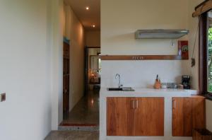 a kitchen with a sink and wooden cabinets at Ashtari - Sky, Sea & Nature in Kuta Lombok