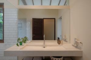 a bathroom with a sink and a mirror at Ashtari - Sky, Sea & Nature in Kuta Lombok
