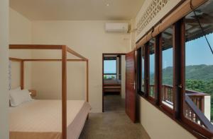 a bedroom with a bunk bed and large windows at Ashtari - Sky, Sea & Nature in Kuta Lombok