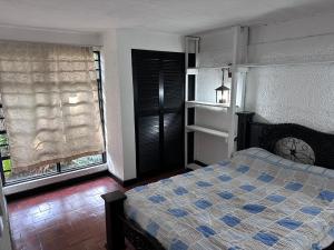 a bedroom with a bed with a blue and white bedspread at APARTAMENTOS VERANERA in Río Oro