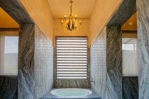 a bathroom with a large window and a bath tub at Surya Bagh - A Luxury Hideaway - 20 minutes drive to Tehla gate, Sariska Tiger Reserve & 10 minute from Bhangarh Fort in Dogeta +71 photos