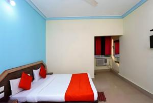 a bedroom with a bed with red pillows at Goroomgo Dittu Holiday inn puri-Near Nilandri Beach-Best Experince Ever in Puri