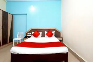 1 dormitorio con 1 cama grande con almohadas rojas en Goroomgo Dittu Holiday inn puri-Near Nilandri Beach-Best Experince Ever, en Puri