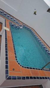 a large swimming pool with blue water in a building at La Casa de Beto in La Manzanilla