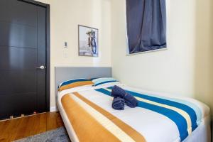 Spacious 4BD Gem in Manhattan في نيويورك: غرفة نوم بسرير من الخطوط الزرقاء والبرتقالية