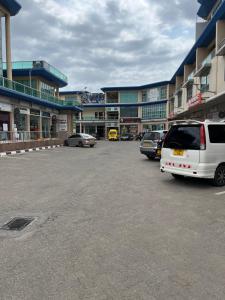 um parque de estacionamento com carros estacionados em frente aos edifícios em Mikocheni smart space em Dar es Salaam