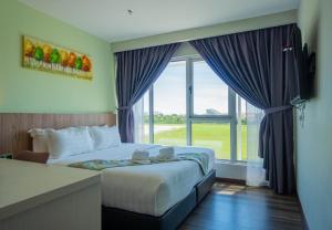 a hotel room with a bed and a large window at FLYPOD Hotel in Kota Kinabalu