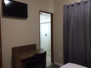 a room with a television on the wall and a bathroom at Cristal Park Hotel in Cristalina