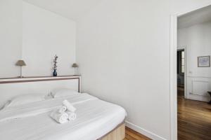een slaapkamer met een wit bed en handdoeken bij Le Marais & Arts et Métiers - CityApartmentStay in Parijs