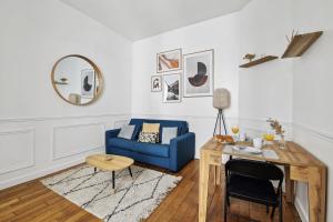 een woonkamer met een blauwe bank en een tafel bij Le Marais & Arts et Métiers - CityApartmentStay in Parijs