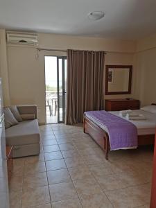 a hotel room with a bed and a couch at Nefeli Apartments in Stoupa