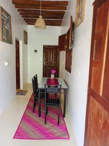 uma sala de jantar com uma mesa e cadeiras num tapete em Happiness House em Shela