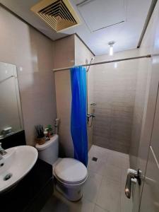 een badkamer met een douche, een toilet en een wastafel bij Condo Suite at 150 Newport near NAIA T3 in Manilla