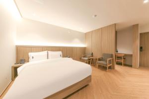 a bedroom with a bed and a table and chairs at Hound Hotel Jeonju Deokjin in Jeonju