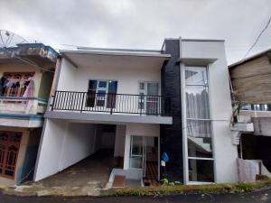 a white house with a balcony on a street at Villa kumudini's in Diyeng