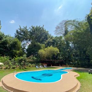 une petite piscine dans un parc arboré dans l'établissement Arcadia Cabañas Vacacionales, à Retalhuleu