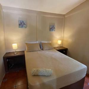 a bedroom with a large bed with two lamps on it at Arcadia Cabañas Vacacionales in Retalhuleu