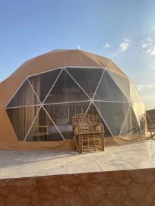 a dome tent with wicker chairs in front of it at Moon Rum Camp in Wadi Rum