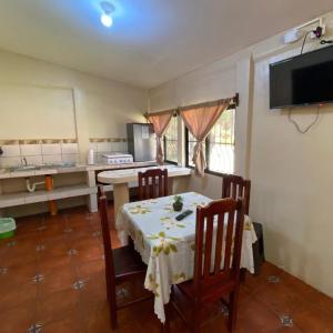 uma cozinha com uma mesa e cadeiras e uma cozinha com uma mesa e uma mesa em Arcadia Cabañas Vacacionales em Retalhuleu