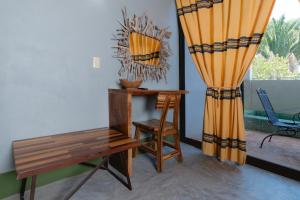 a room with a desk and a chair and a window at Nopalero Suites Hostel in Puerto Escondido