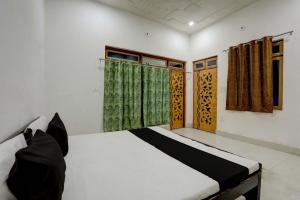 a bed in a room with two windows at OYO 82103 Royal guest house in Morādābād