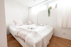 a bedroom with two beds with white sheets and a window at 2ndhomes Ullanlinna Penthouse Apartments in Helsinki