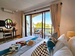a room with a bed with a tray of food on it at Hoian Village Lodge by Label6 in Hoi An