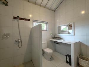 y baño con aseo, lavabo y ducha. en Alam Cottage Uluwatu, en Uluwatu