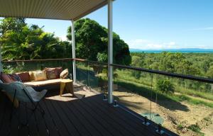 eine Veranda mit einem Sofa und Blick auf die Bäume in der Unterkunft DUENDE Sirène Mermaid in Midgeton