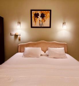 a bedroom with a bed with white sheets and two pillows at Luna Waves in Negombo