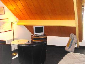 a room with a bed, desk, chair and a lamp at Hôtel Duguay-Trouin in Cancale